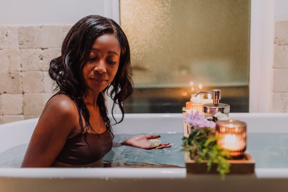A serene moment of relaxation in a bath with flowers, candles, and aromatherapy.